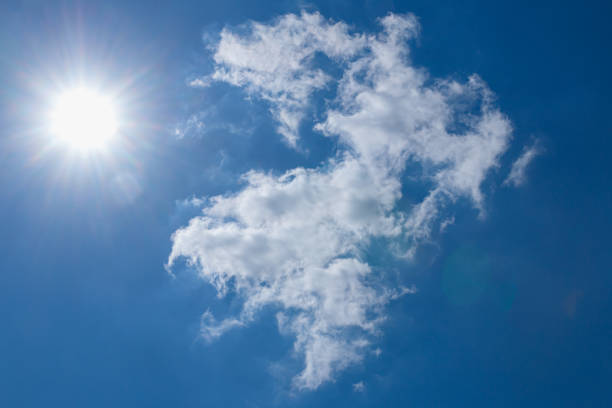 Sunbeams in summer with  white clouds on a blue sky background