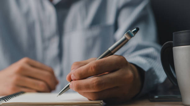 istock Male hand taking notes on the notepad. businessman working at work table, checklist writing planning investigate enthusiastic concept. focus on man hand holding pen, putting signature at official paper. 2162963053