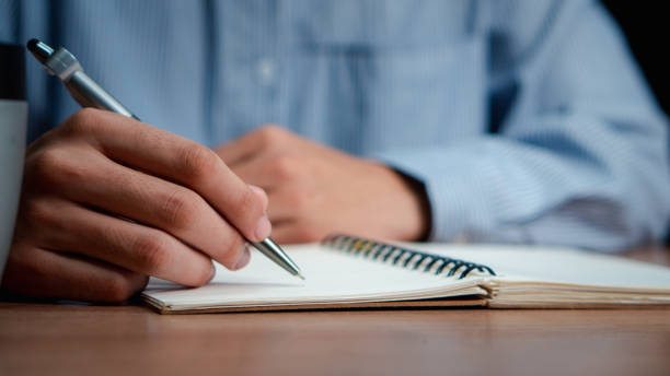 istock Male hand taking notes on the notepad. businessman working at work table, checklist writing planning investigate enthusiastic concept. focus on man hand holding pen, putting signature at official paper. 2162963067
