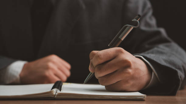 istock Male hand taking notes on the notepad. businessman working at work table, checklist writing planning investigate enthusiastic concept. focus on man hand holding pen, putting signature at official paper. 2162963096