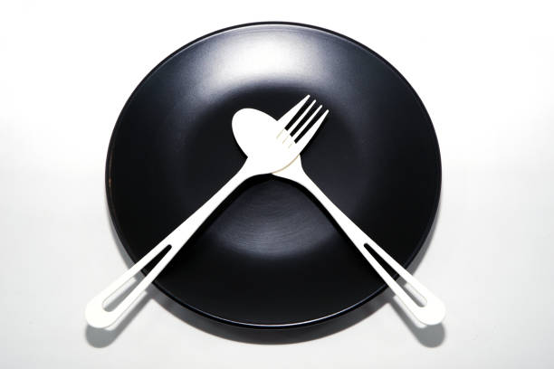 Empty plate with cutlery set isolated on white background close-up view top down view