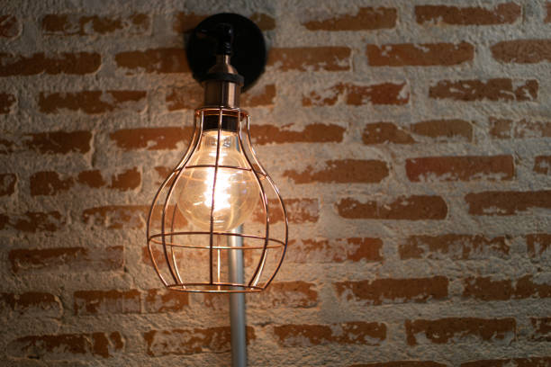 Vintage Industrial Edison Lamp Lighting Fixture Illuminating Cozy Rustic Brick Wall with Warm Glow of Filament Bulb in Loft or Home Decor