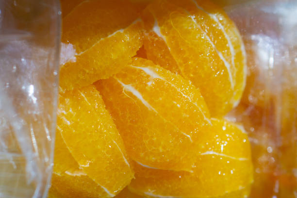 Closeup of Freshly Sliced Juicy Orange Citrus Fruit on Transparent Studio Background. Detailed Texture and Vibrant Color of the Ripe and Organic Citrus Segment.