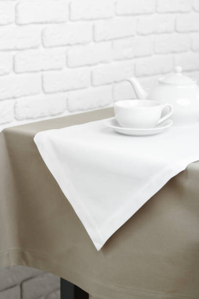 istock Beige Tablecloth on White Brick Wall With Teacups and Teapot 2162967507