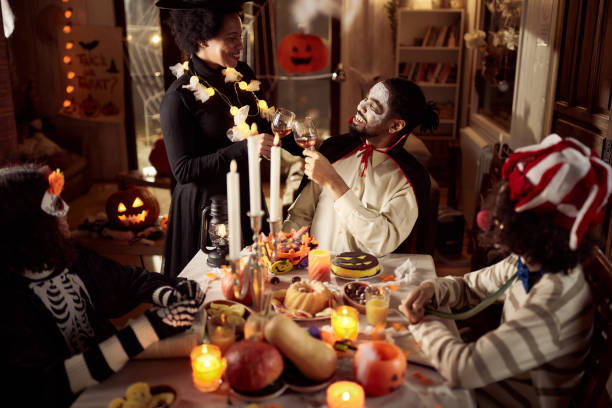 istock Happy black parents toasting during Halloween in dining room. 2162968030
