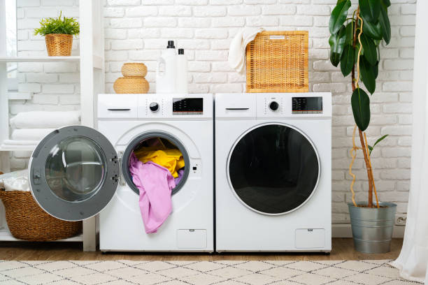 istock Open Washing Machine With Pink and Yellow Clothes in a Modern Laundry Room 2162968544