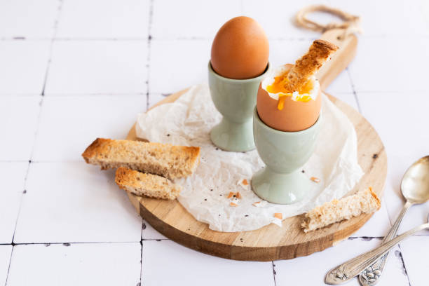 Boiled chicken eggs with toasted bread on egg cup. Healthy food. Copy space.