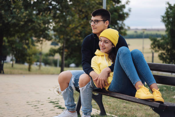 istock Content couple embracing and smiling on park bench 2162970215