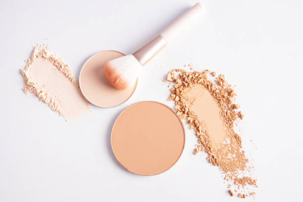 istock cosmetic background with texture samples of compact and loose powder in different tones. A chic makeup brush. top view. white background 2162971435