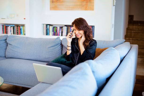 istock Mid aged woman using smartphone and laptop at home 2162972635