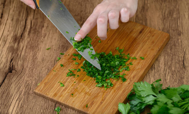 istock Chopped green parsley leaves on a kitchen knife 2162972717