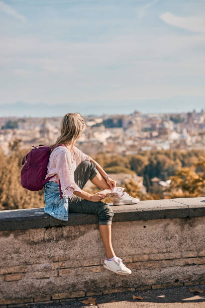 istock Young female tourist reading a map while exploring big city 2162973456