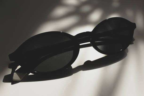 istock Sunglasses on a white table in the shade from sunlight 2162974778