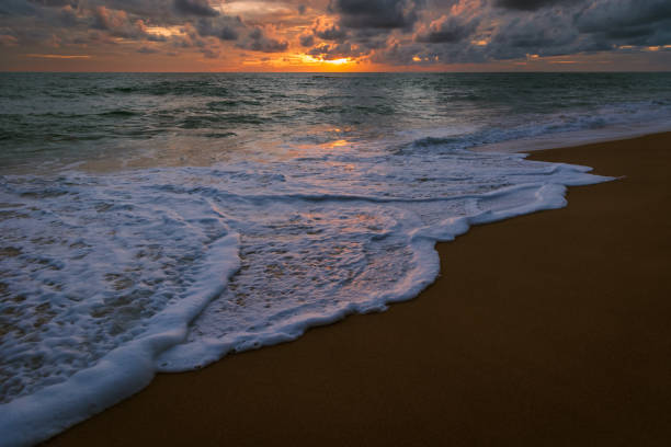 Amazing sunset form Thailand beach. Sunset with sandy beach with waves. Dramatic sky sunset on a sandy beach in Thailand. Stormy clouds over the beach.