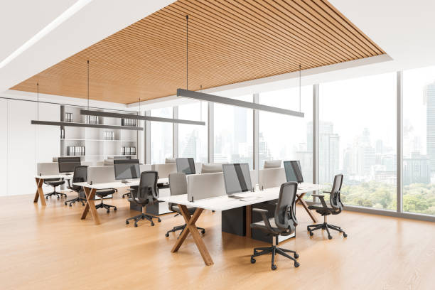 istock Modern coworking interior with office tables and pc computers near window 2162975898