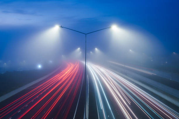 istock Foggy weather and traffic light trails on highway. 2162976162