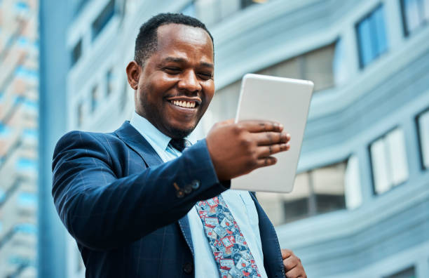 istock Happy Black Businessman Using Tablet Outdoors in City 2162976244