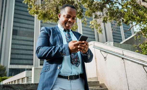 istock Confident Black Businessman Using Smartphone Outdoors in City Setting 2162976260