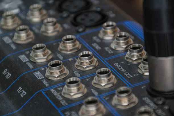 row of silver gold audio input connectors, on a professional audio mixing console or desk