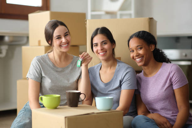 istock Three happy roommates showing keys moving home 2162979282