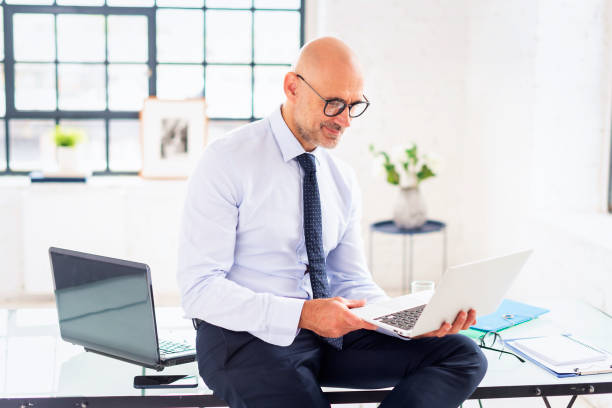 istock Mid aged man sitting at the office and using his laptop for work 2162980306