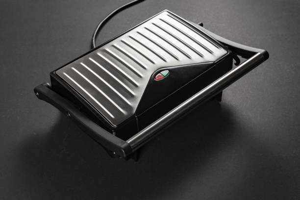 istock Modern electric grill on dark background. Fried meat and boiling fat 2162981923