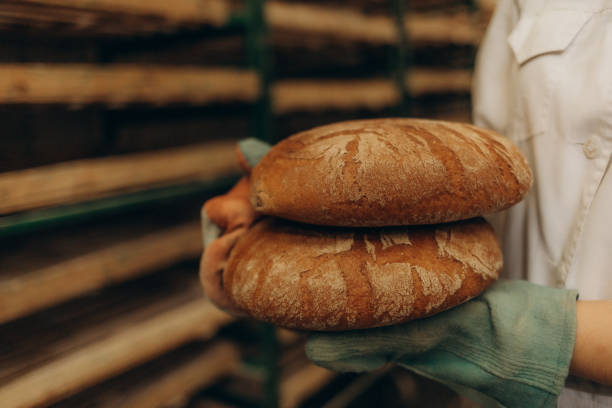 istock Homemade sourdough bread. Bright white kitchen. Bread on cutting board. Kitchen utensils. Craft authentic bread. Home cooking. Food preparation. Coronavirus covid-19 stay home isolation quarantine. 2162982375