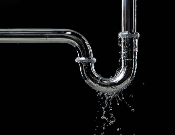 istock Drain leak water from pipe plumbing in bathroom as water clogged drop. Black background isolated. Leaking water from chromium stainless steel pipe under sink 2162984103