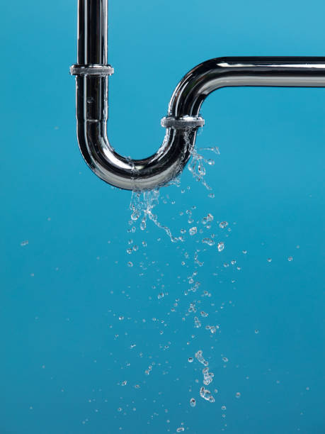 istock Leaking water from chromium stainless steel pipe under sink. Drain leak water from pipe plumbing in bathroom as water clogged drop. Blue bathroom background isolated 2162984127