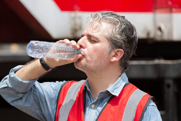 istock Male engineer construction drinking water at construction site. Male construction builder drinking water at site work 2162987983