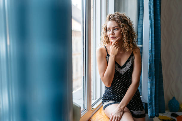 istock Depressed Young Woman Sitting By The Window In Budapest 2162988182