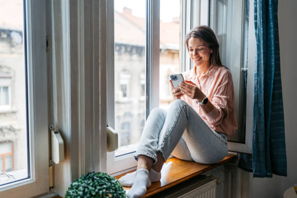 istock Young Woman Using Phone By The Window In Budapest In The Morning 2162988851