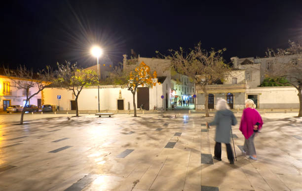 Two women strolling through a town square