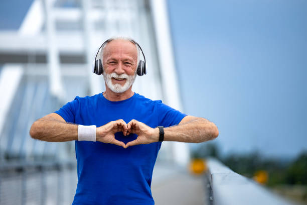 Senior man showing heart shape after running training.