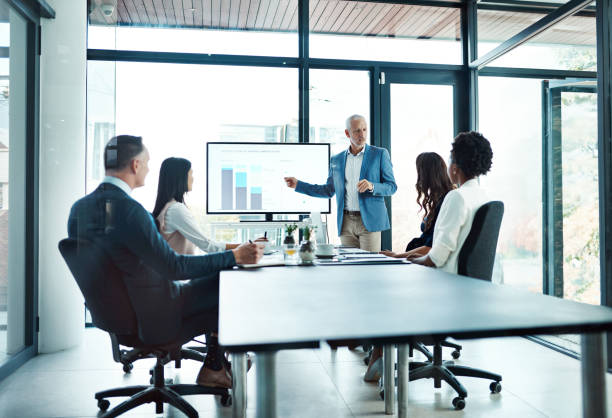 istock Corporate training, team and man with presentation, leader or graph for financial growth, budget or charts. Male person, employee or accountant with group, staff or coworkers in a meeting and talking 2162995937