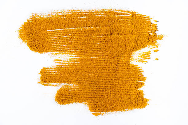 A smear of turmeric on a white background, top view.