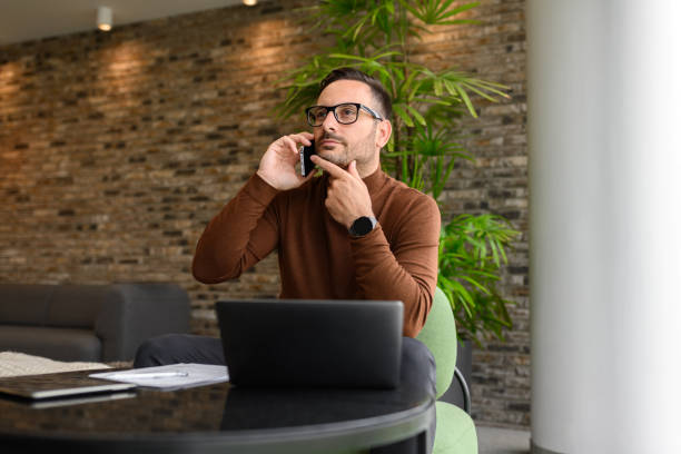 istock Inspired financial advisor discussing with client over smartphone while working over laptop in office 2162998077