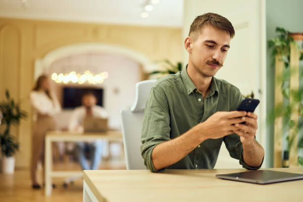 istock A man with a mustache uses a mobile phone while working at the co-working space. 2162999041
