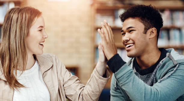 istock Women, man and high five at university for education, teamwork or success for thesis. Students, celebrate and happiness with hands together for knowledge, collaboration or partnership for school work 2162999230