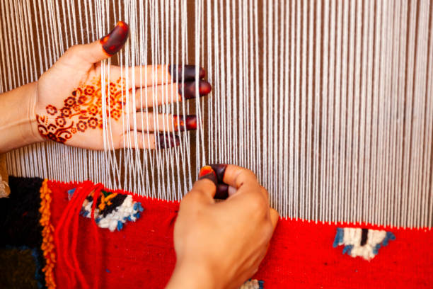 Berber woman weaving a carpet in a traditional house, Ouarzazate, Morocco. This old fashined form of weaving is very popular in the High Atlas mountains, specially in villages near Ouarzazate town.