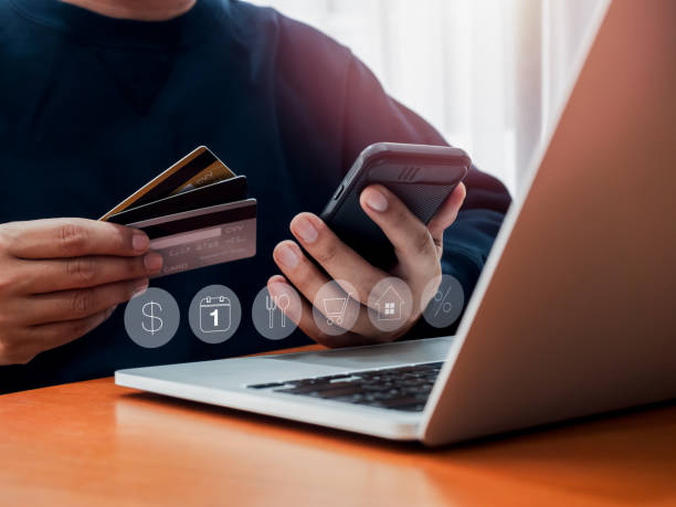 istock Credit card fee debt concept. Many credit cards in hand while businessman using mobile smart phone for calculate expenses, monthly paying, loan, online shopping and banking, digital transaction icon. 2163000833