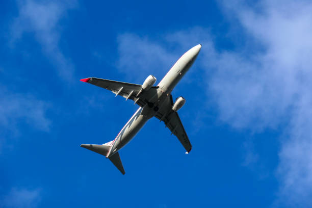 A Qantas Boeing B737-838 plane, registration VH-VXQ in Retro 1959 Livery, taking off from the east-west runway of Sydney Kingsford-Smith Airport as flight QF924 to Cairns. This image was taken from next to the Cooks River, Banksia on a cold, windy and sunny afternoon on 20 July 2024.