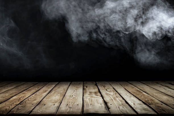 istock Wooden board table top with empty copy space and black wall with smoke background. 2163001971