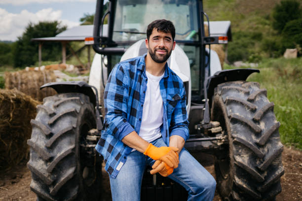 istock Man farmer standing in front of tractor 2163003302