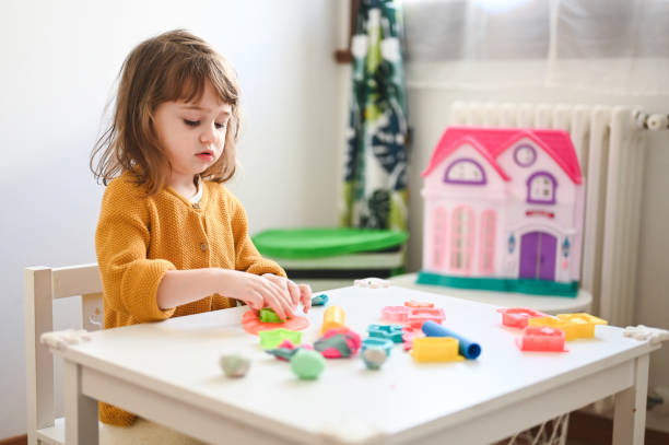 istock little girl play with modeling clay 2163005884