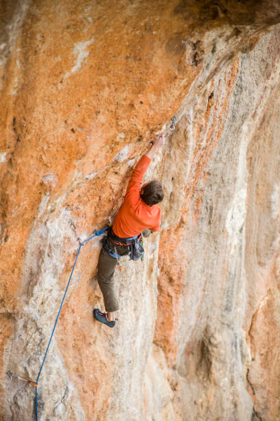istock A rock climber climbs to the top along a difficult route. 2163005940