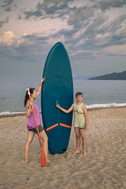 istock Mother and son are spending time together on the beach, preparing for paddleboarding after sunset. They are having fun and enjoying in precious moments together while enjoying their summer adventure. 2163006028