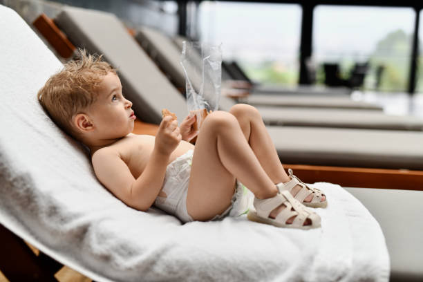 Toddler Contemplating Quality Of Biscuits While Relaxing On Chaise Lounge