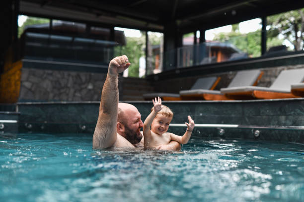 istock Success And Fun For Father And Son In Swimming Pool 2163011705