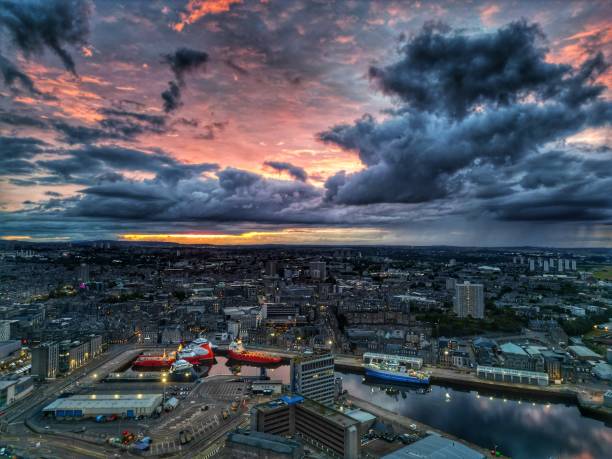 A cloudy sunset over the city of Aberdeen with the harbour area in the foreground.